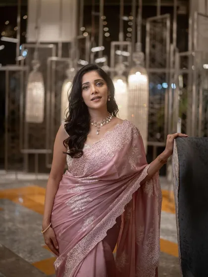 A timeless look for the lovely Milana Nagaraj. This pastel pink saree is paired with a custom-designed blouse featuring delicate white embroidery, creating an outfit that is both elegant and unforgettable.