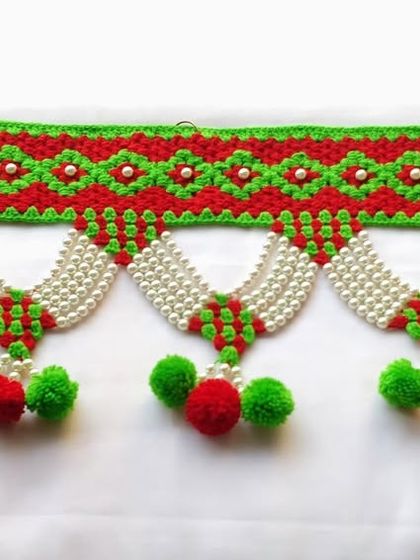 A full, clear view of the red and green Moti toran, a classic choice for festivals and celebrations.
