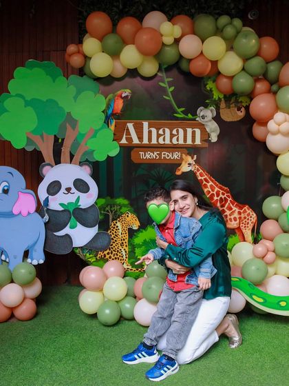 A mother holds her son in front of the jungle backdrop. These are the precious photos that families will look back on for years to come.