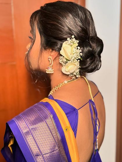 A simple and elegant bridal bun for a Maharashtrian bride, adorned with a few white roses and baby's breath. Sometimes, less is more.