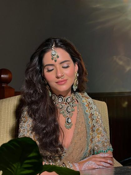 The bride with her eyes closed, exuding a sense of calm and power. The makeup is impeccable, creating a look that is both strong and serene.