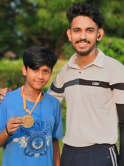 This student's performance was outstanding. He is holding his medal, a symbol of his victory and effort.