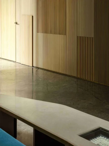 The powder room at the Bammi Residence, where wooden fluted paneling conceals the door, creating a seamless wall. This detail exemplifies our approach to integrating function and aesthetics.