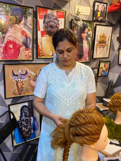 Another shot of a student perfecting her work. The background shows the inspiring environment of my salon, filled with examples of advanced hairstyling.