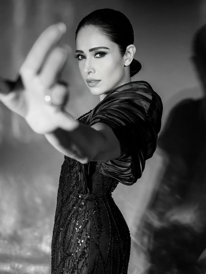 An expressive pose from the same monochrome series, where the hand reaching towards the camera adds depth and a dynamic element.