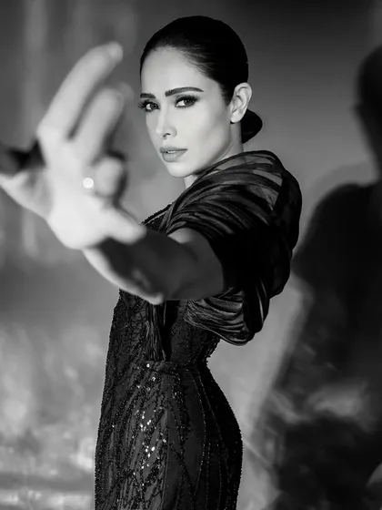 An expressive pose from the same monochrome series, where the hand reaching towards the camera adds depth and a dynamic element.