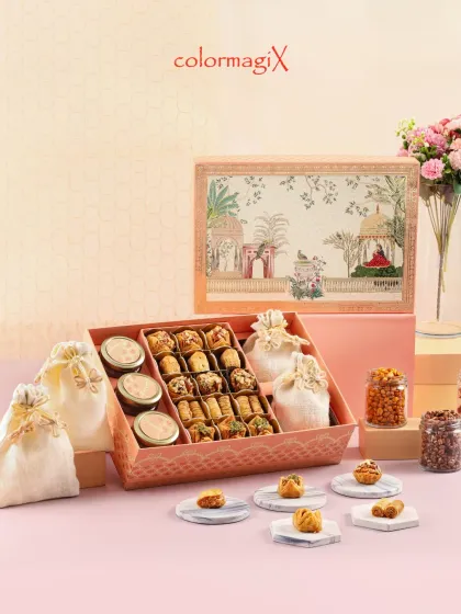 This elegant hamper features a beautiful Pichwai art design on the lid. Inside, it holds a delightful assortment of sweets, snacks in jars, and treats in decorative potlis.