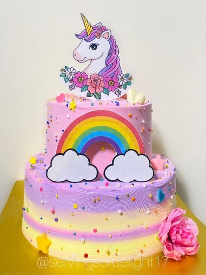 A magical two-tier unicorn and rainbow cake. The pastel colors and sparkly details are perfect for a dreamy birthday party.