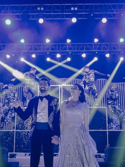 The couple takes center stage for their Sangeet performance, backed by professional dancers and dramatic lighting.