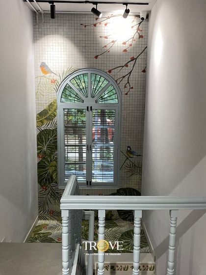 This beautiful staircase landing is transformed by a custom tile mural featuring birds and botanicals, designed to look like a window to the outdoors. It shows how I can use bespoke tile art to brighten narrow spaces and create an illusion of depth and nature.