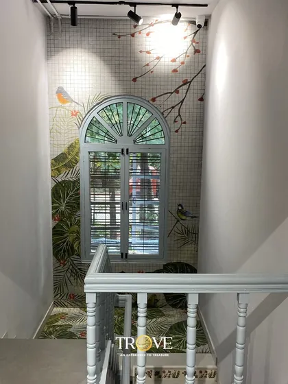 This beautiful staircase landing is transformed by a custom tile mural featuring birds and botanicals, designed to look like a window to the outdoors. It shows how I can use bespoke tile art to brighten narrow spaces and create an illusion of depth and nature.