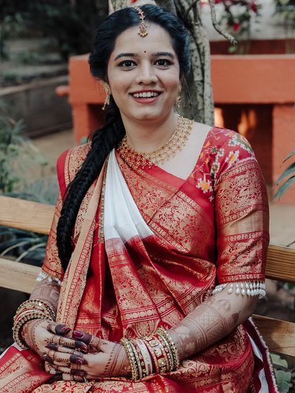 A beautiful portrait of the same smiling bride, her hands adorned with a lovely, rich mehendi stain.