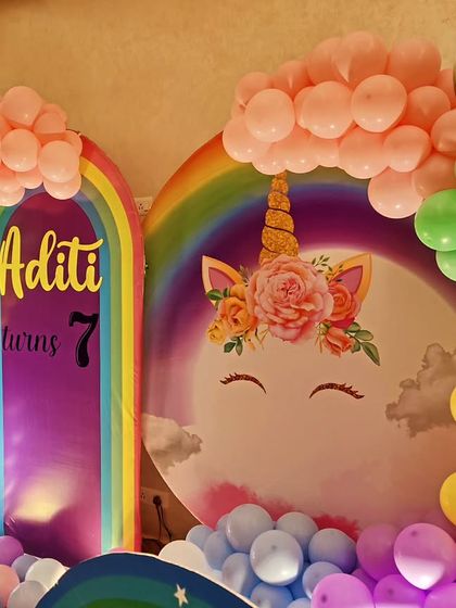 A close-up of a unicorn and rainbow-themed backdrop, showing the colorful balloon arch.