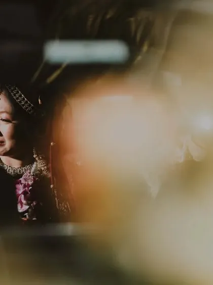 She steps into the light, leaving behind tears that glisten with the promise of forever. An emotional, artistic shot of the bride's vidaai.
