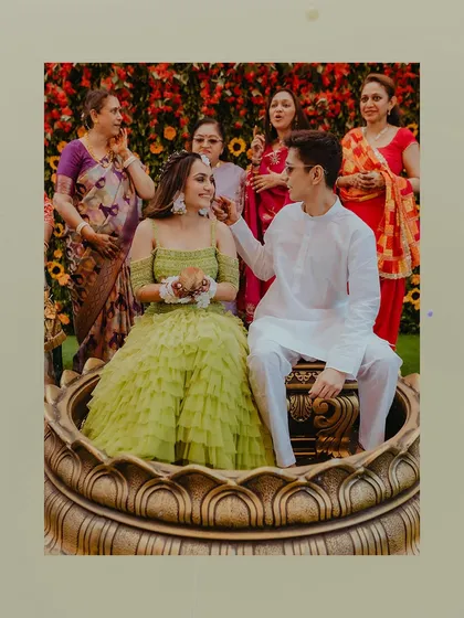 A sweet moment between the couple during their Haldi ritual, seated in a large decorative urn.