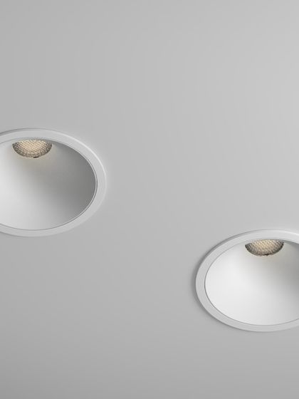 Two of our recessed downlights are shown installed flush against a ceiling. This image highlights their minimalist design, where the fixture itself is nearly invisible, providing a clean look while delivering a soft, pleasant wall-washing effect.