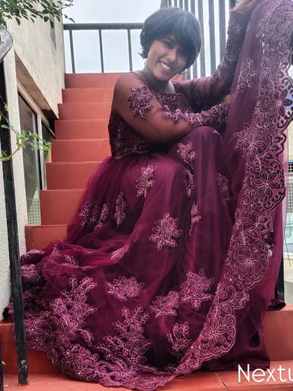 A graceful pose on the stairs, showcasing the beautiful embroidery of the gown.