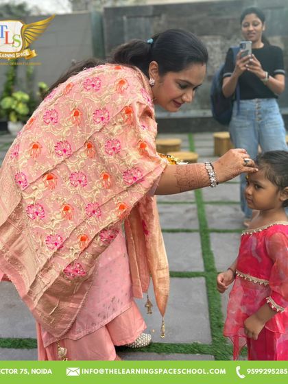 A mother applies a tilak, welcoming a child to the celebration. We strive to create a warm and inclusive environment for all our families during festive times.