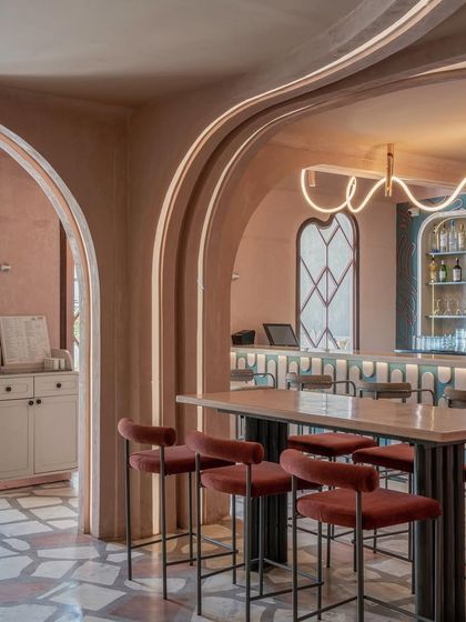 The high-top seating area at Hangover, framed by lathe-plastered archways. The design uses architectural curves and custom lighting to create a visually interesting and cohesive environment.