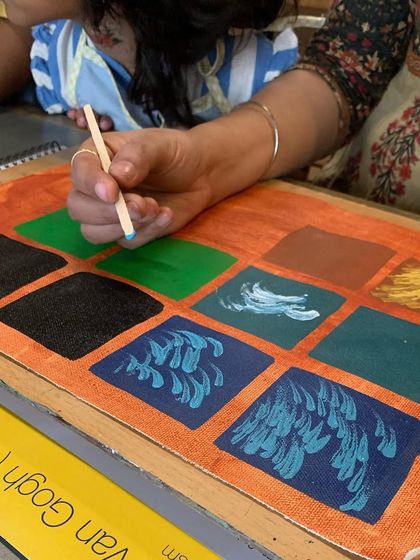 Learning about Van Gogh's brushstrokes. A student practices creating different textures with paint before applying them to the final piece.