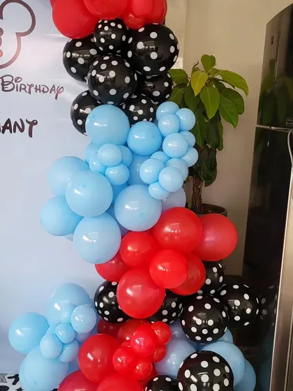 A close-up of the balloon garland for the Mickey Mouse theme, using red, light blue, and polka-dotted black balloons.