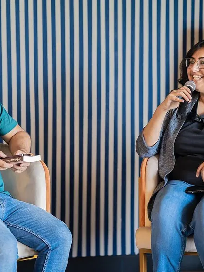 The host and author Shuchi Batra in a lighthearted moment during the Q&A session, set against a stylish backdrop.