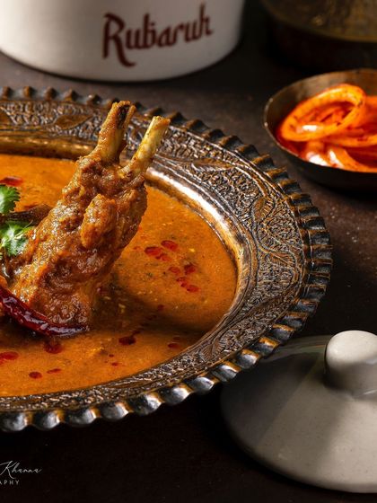 A close-up of the Mutton-e-Rubaruh, focusing on the tender meat on the bone in a rich gravy.