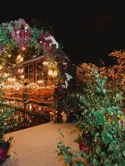 The magical, floral-covered entrance to an evening event, creating a sense of anticipation and wonder.