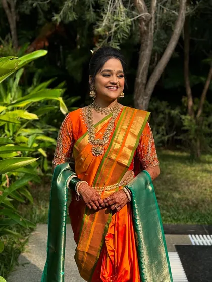 A traditional bun styled for a Nauvari saree look. This classic updo is essential for Maharashtrian brides, providing a secure base for traditional jewelry and flowers.