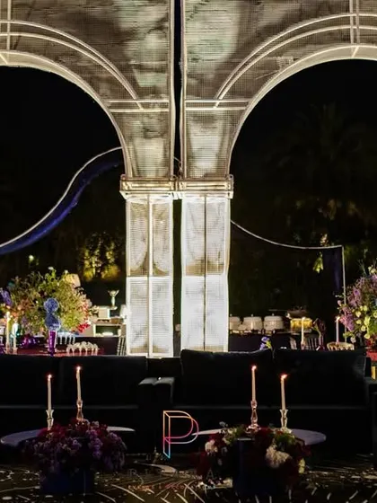 We designed these illuminated white arches to frame the lounge area, creating a futuristic, architectural element. The dark velvet sofas and celestial-print carpet complete the cosmic vibe.