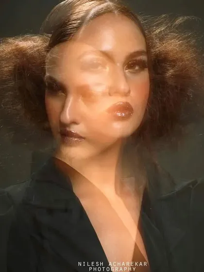 An experimental editorial look using in-camera motion blur effects. The makeup features glossy lips and defined eyes, designed to look striking even when distorted for an artistic photo.