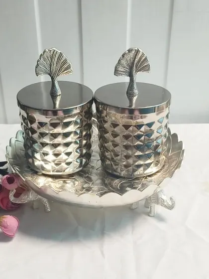 This German silver dry fruit set includes two textured jars and a matching tray with elephant-shaped feet. The ginkgo leaf detail on the lids adds a touch of modern elegance.