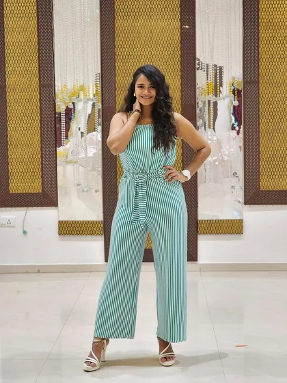 A confident pose in the striped jumpsuit. This versatile outfit is perfect for a variety of settings, from a casual day out to a semi-formal event.