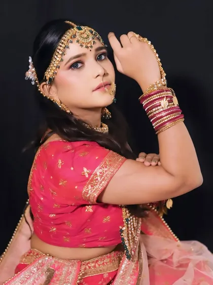 A powerful pose from a bride, showing off her intricate jewelry and confident look. The makeup is designed to be bold yet elegant.