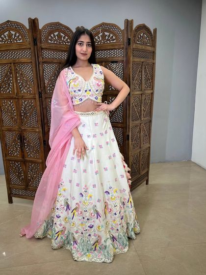 A beautiful off-white lehenga with colorful bird and floral embroidery. This pre-loved piece is unique, artistic, and perfect for a daytime wedding.