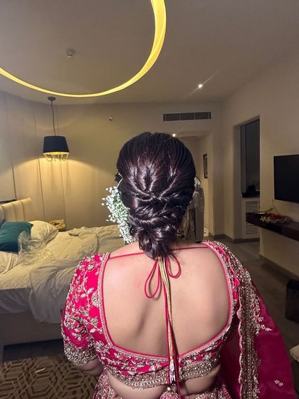 A detailed look at a modern, textured updo. This style involves intricate weaving and twisting to create a glossy, structured look that is perfect for a reception or cocktail event.