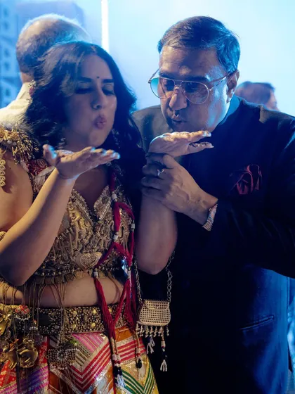 A bride and her father share a playful moment, blowing kisses to the camera. It’s a sweet and fun interaction that shows the joyful side of their relationship on the wedding day.