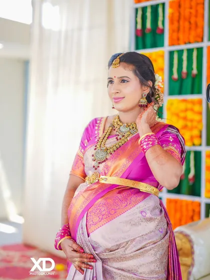 A candid shot of the mother-to-be adjusting her jewelry, capturing a natural and unposed moment during the celebration.