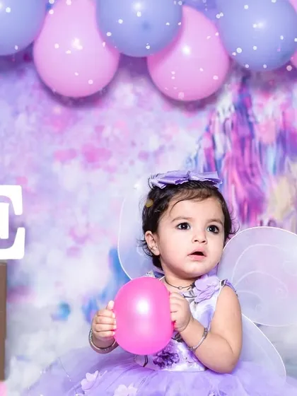 A little fairy in a magical lavender wonderland. This first birthday session was designed with dreamy colors, fairy wings, and soft lighting to create an enchanting portrait.
