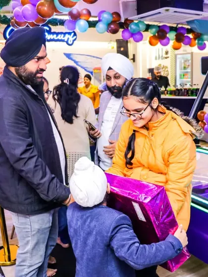 The birthday boy receives a gift from his friends and family during his party. These are the precious moments that make celebrations here so special.