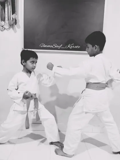 "Life won't get easier, we have to become stronger." Two young boys practice their stances, learning the core principles of karate and self-defense.