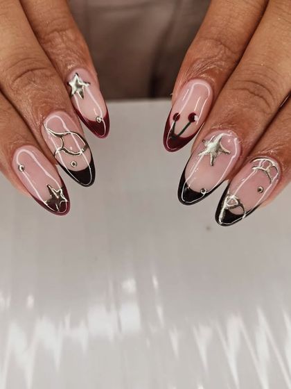 An edgy and celestial-inspired design. This set features black French tips with 3D silver chrome stars, moons, and abstract shapes for a truly unique look.