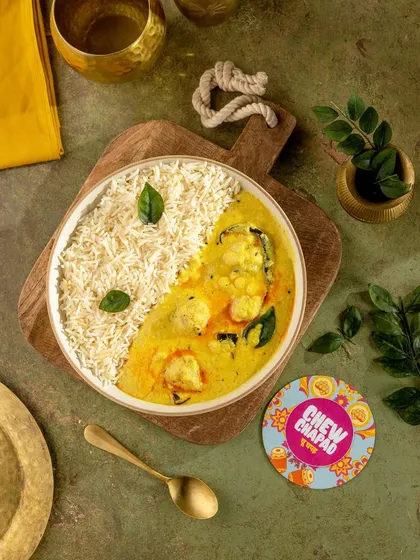 A beautifully balanced bowl of Kadhi Chawal. The yin-yang presentation is visually striking, and the overhead angle captures the creamy texture of the kadhi against the fluffy rice for a clean, modern look.