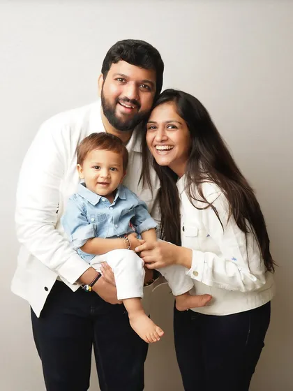 A joyful family portrait. The coordinated white and denim outfits create a clean, classic look that keeps the focus on their happy faces.