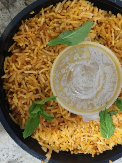 A single-serving packed biryani, complete with raita. This is a popular and convenient option for individual corporate lunch orders.
