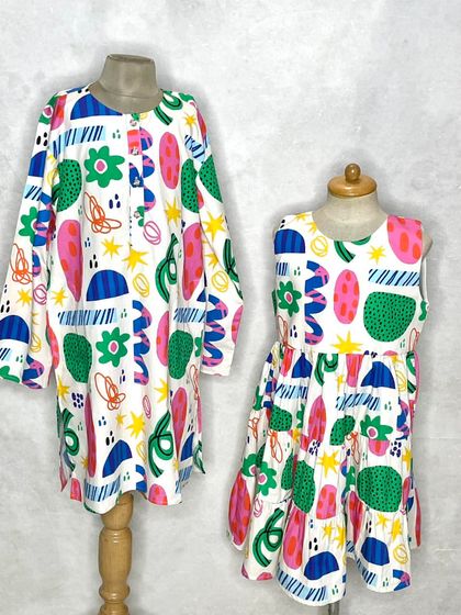 Another coordinated sibling look in our "Fun Shapes" print. Here, the brother wears a long-sleeved tunic while his sister wears a tiered dress.