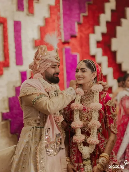 Capturing the joy after the garlands are exchanged. This candid moment, set against a custom floral backdrop, shows the beautiful, unscripted emotions that I strive to create space for amidst the grand ceremonies.