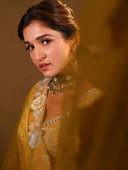 A dreamy, artistic shot through the dupatta. This highlights the soft-focus beauty of the makeup and creates a very romantic mood.