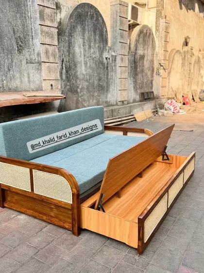 A practical and stylish solution for hotel rooms, this custom-built sofa-cum-bed features a solid teak wood frame with cane accents. The pull-out mechanism reveals ample storage space, making it a highly functional piece for maximizing room utility.