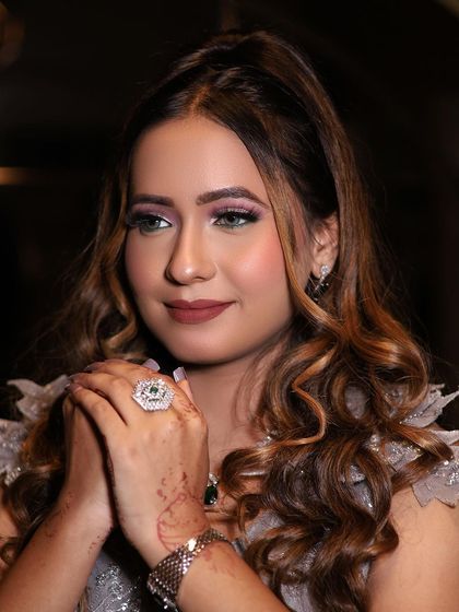 A close-up of Prachi's engagement look. The soft curls, shimmery eyeshadow, and confident pose showcase a modern and chic style.